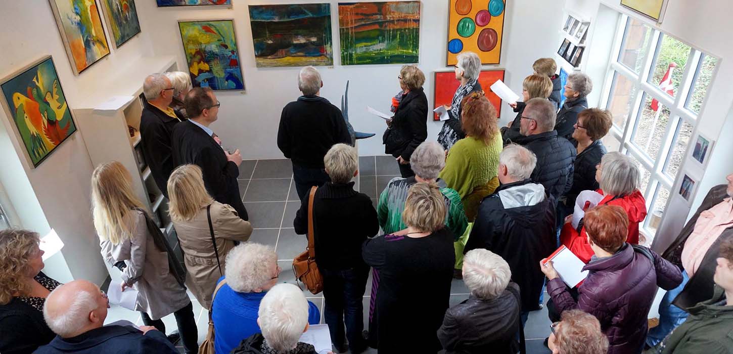 Die Gäste sehen sich die in der Werkstattgalerie ausgestellten Kunstwerke an