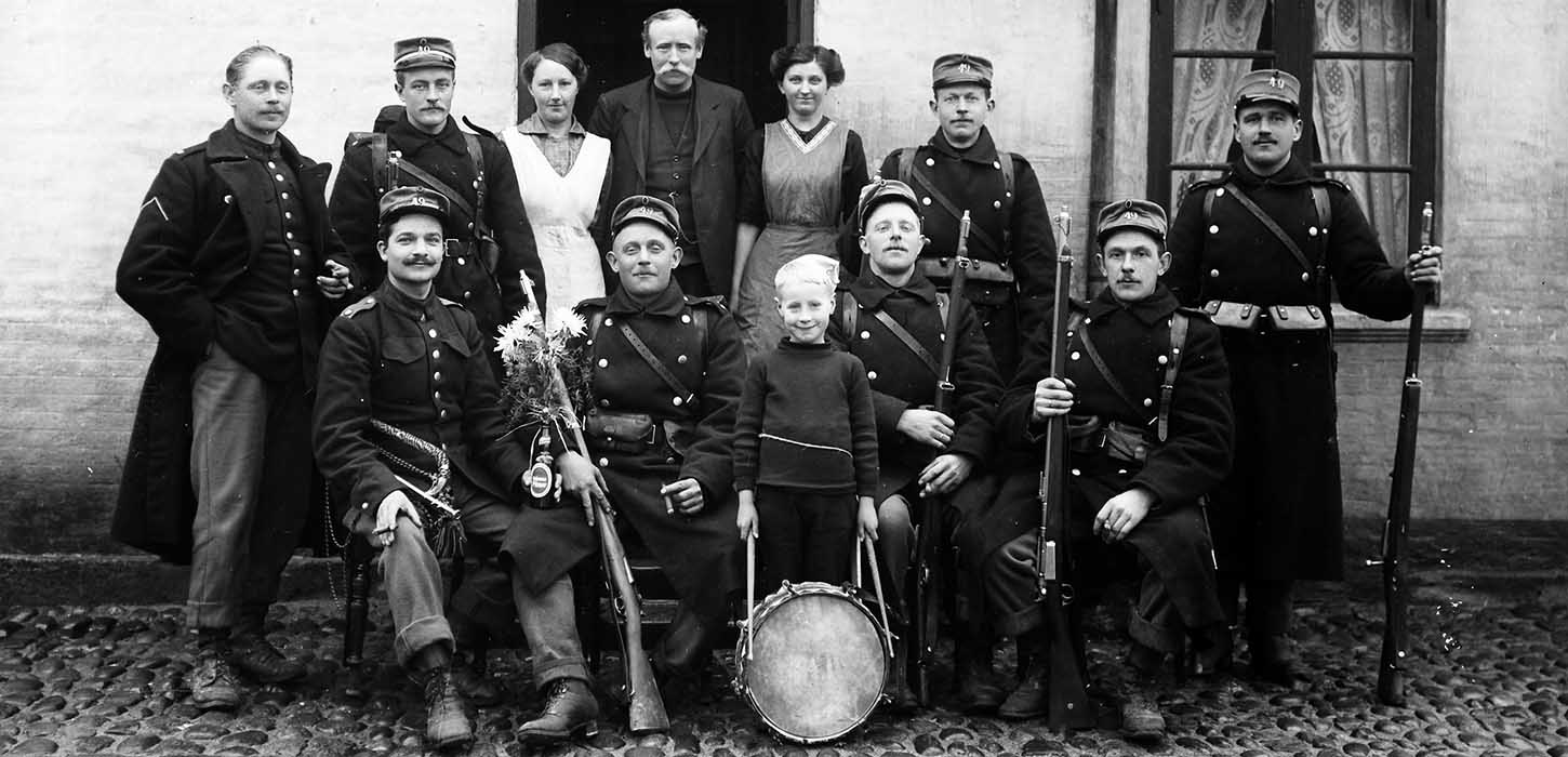 Eine Gruppe von Soldaten mit Gewehren und ein Junge mit einer Trommel