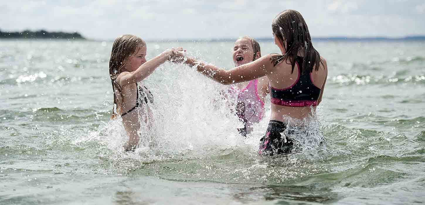 Tre piger bader ved stranden på Nordfyn