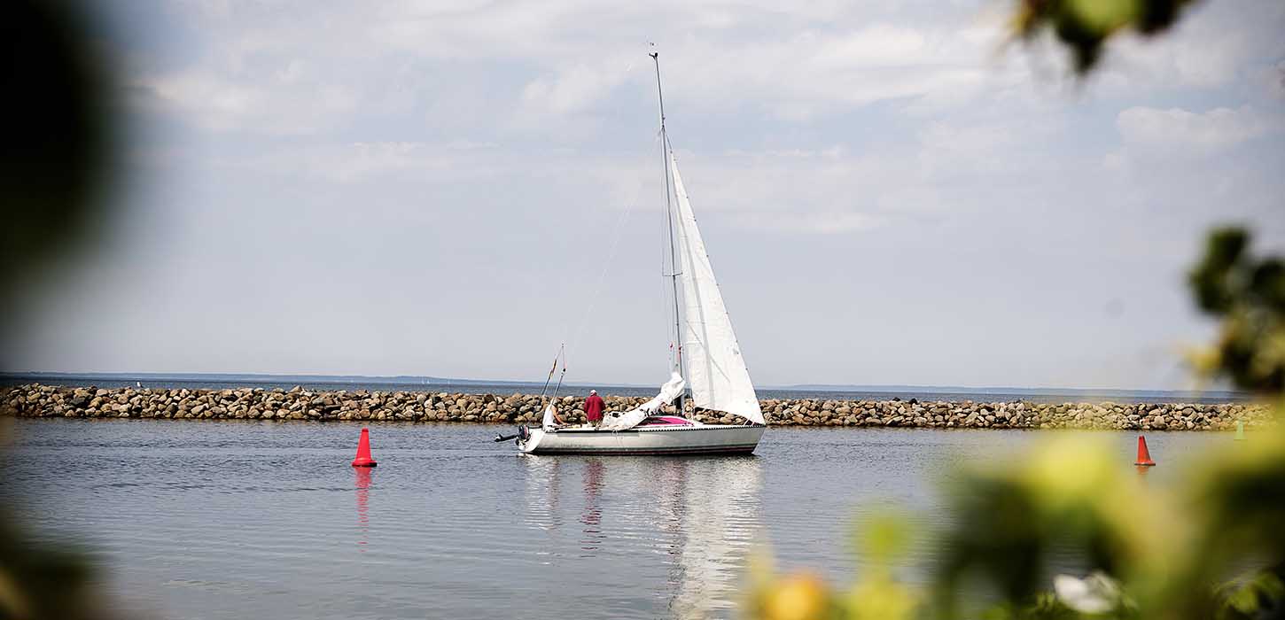 Lystsejler båd sejler ind i Bogense Marina i sommertid