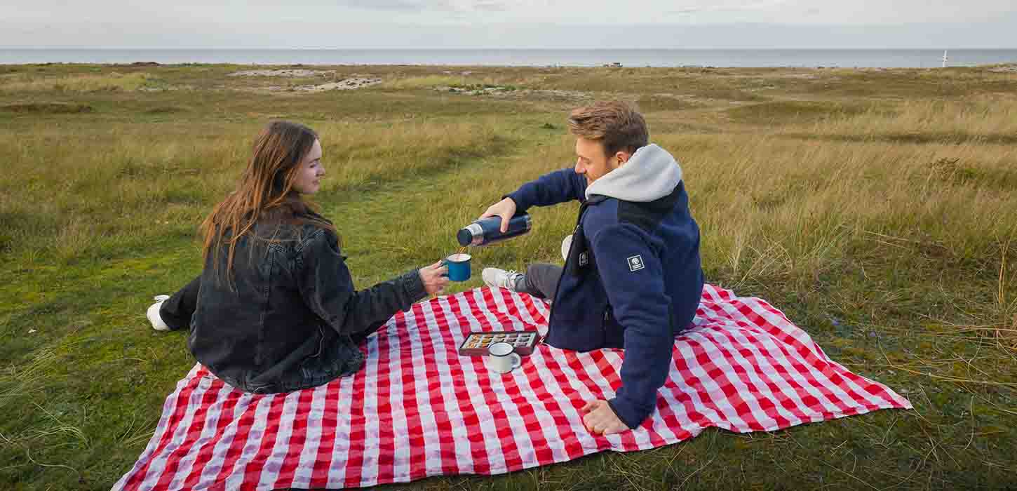 Par nyder madpakke og kaffe ved Flyvesandet