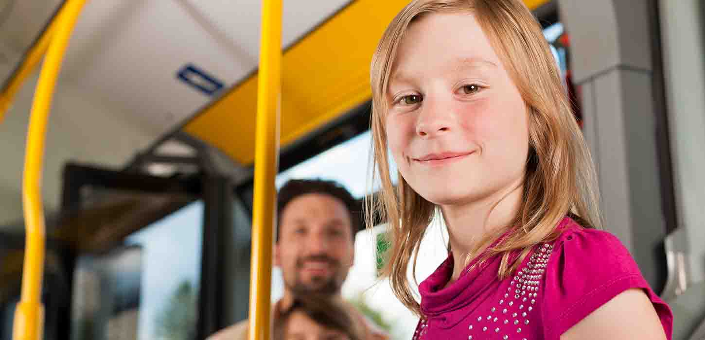 Pige i bus smiler til kamera
