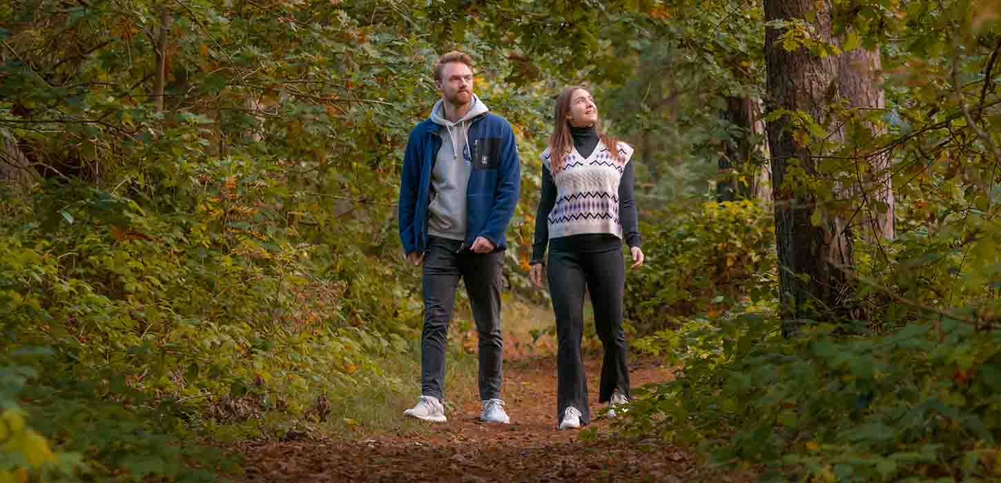 Par går tur i skoven ved Flyvesandet i efteråret
