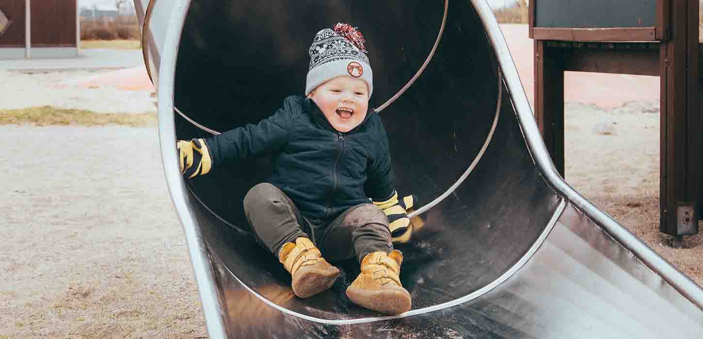 Dreng griner i rutsjebane i vintertid