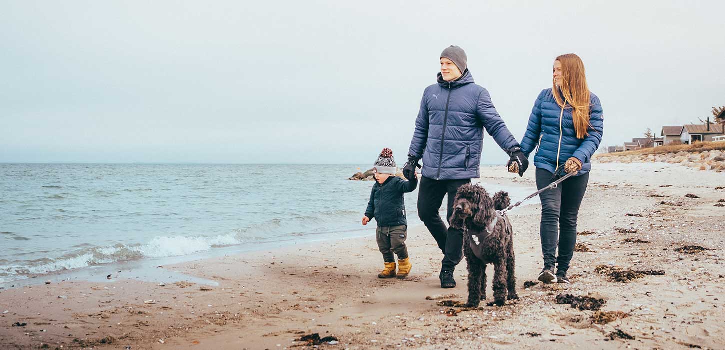 Mor, far, barn og hund går tur på Fuglsang Strand i vintertid