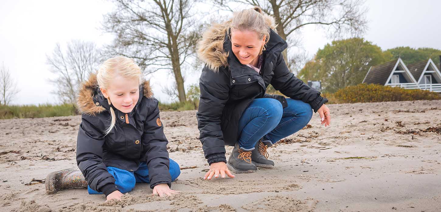 Mor og datter leger på Hasmark Strand i efterårs- og vintertiden