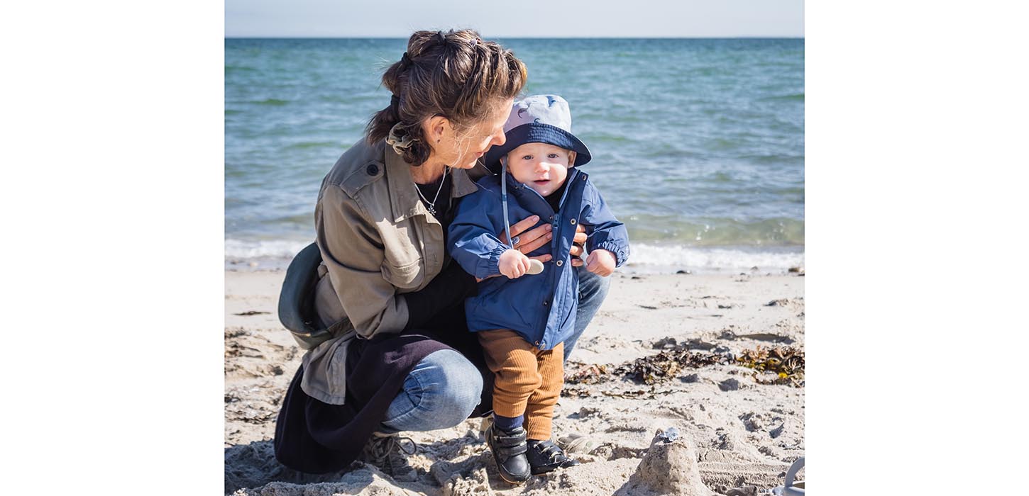 Bedstemor med barnebarn på stranden ved Fuglsang Strand