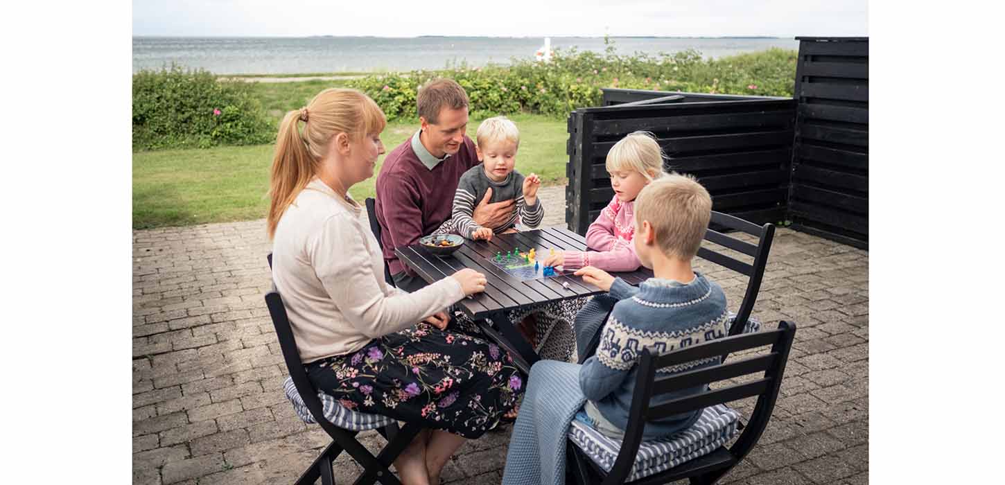 Familie spielt ein Brettspiel im Ferienhaus in Hasmark