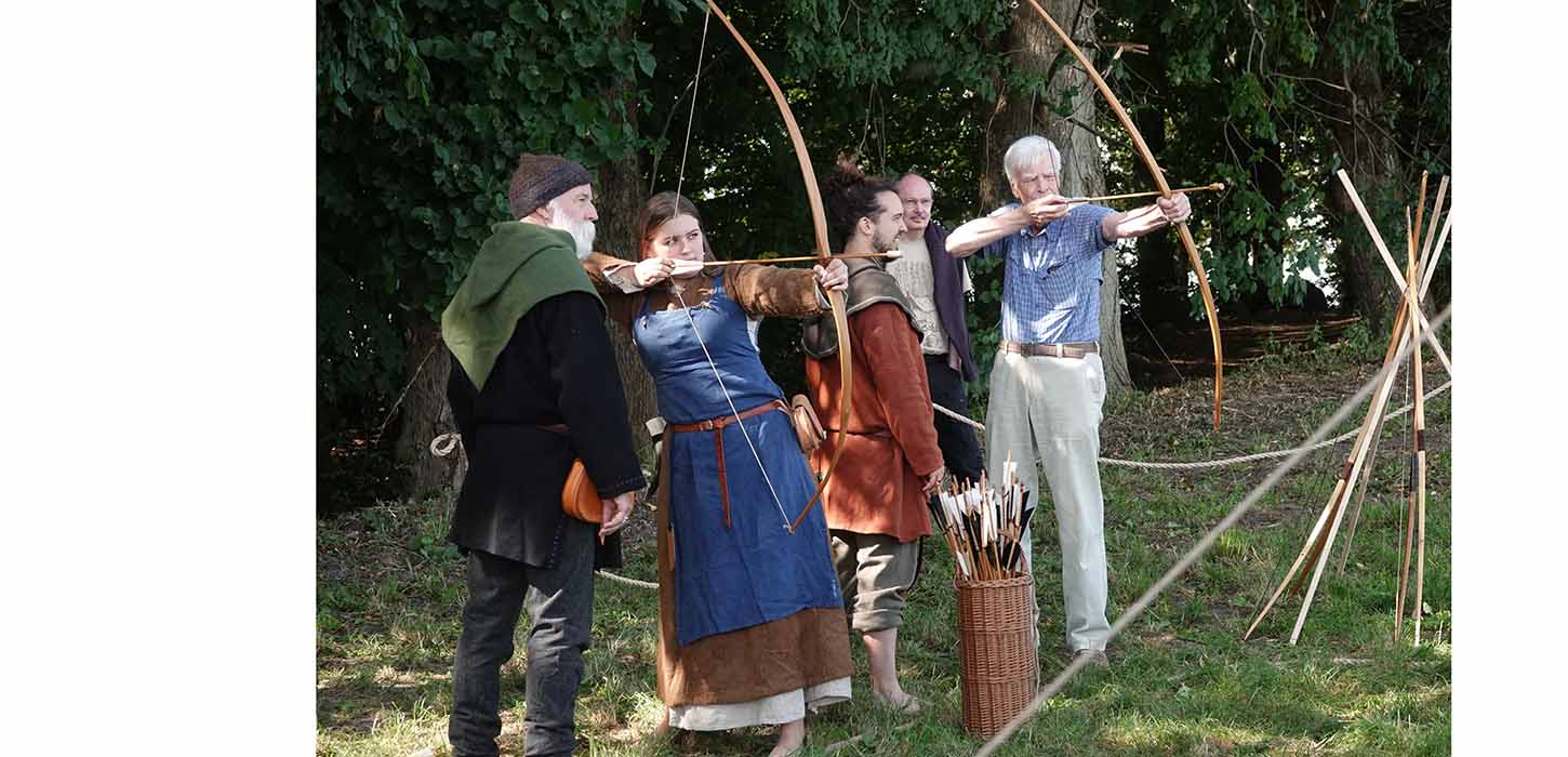 Eine Frau schießt mit Pfeil und Bogen auf dem Wikingermarkt